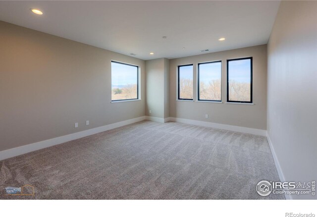 empty room featuring light carpet, visible vents, baseboards, and recessed lighting