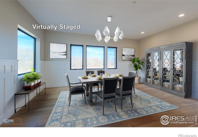 dining space with a wainscoted wall, dark wood-style floors, a chandelier, a decorative wall, and recessed lighting