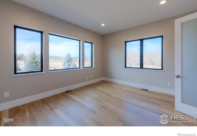 unfurnished room featuring light wood-type flooring, recessed lighting, and baseboards