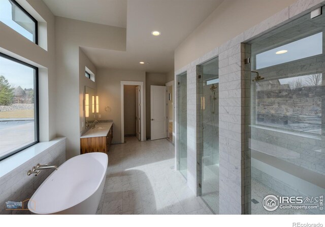 bathroom featuring a freestanding bath, a stall shower, vanity, and recessed lighting