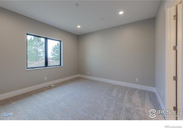 carpeted empty room featuring baseboards, visible vents, and recessed lighting