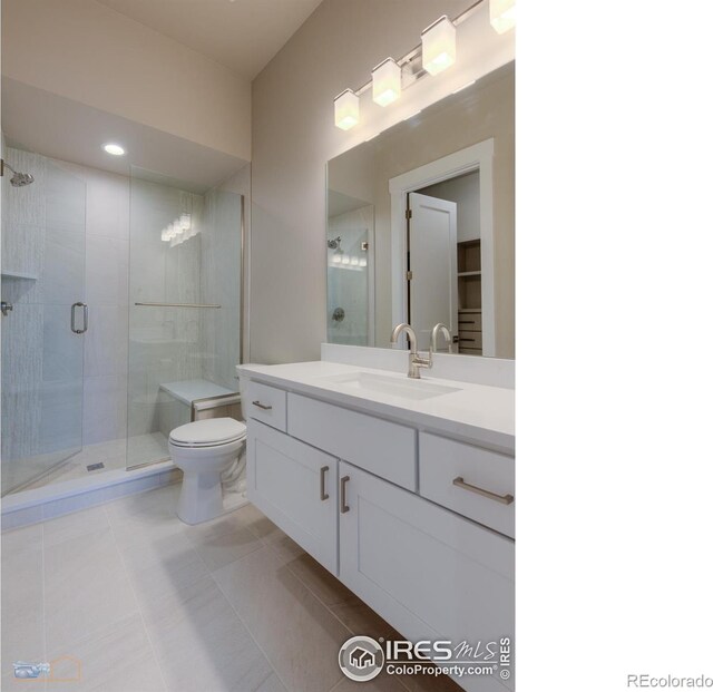 bathroom featuring recessed lighting, toilet, a stall shower, vanity, and tile patterned floors