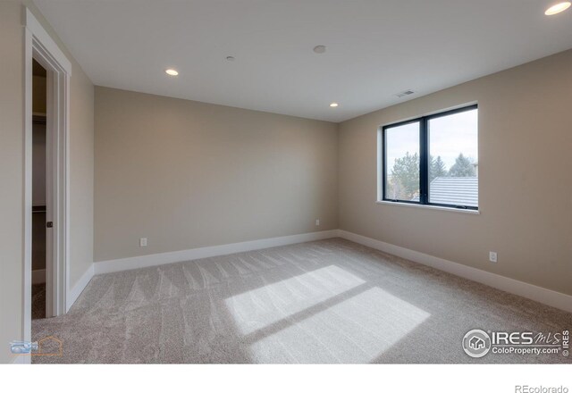 empty room featuring baseboards, light colored carpet, and recessed lighting