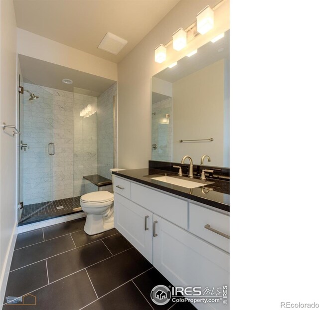 full bathroom with a stall shower, vanity, toilet, and tile patterned floors