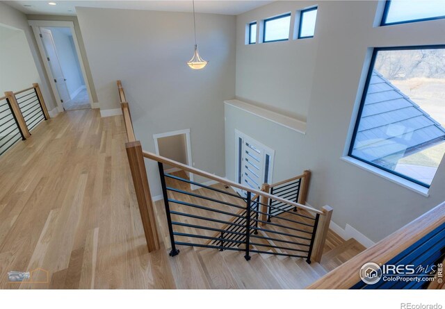 stairs with baseboards, wood finished floors, and recessed lighting