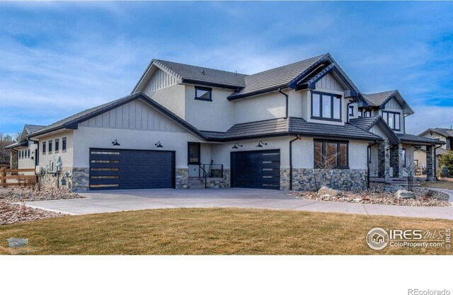 view of front facade featuring a tile roof, stone siding, driveway, stucco siding, and a front yard