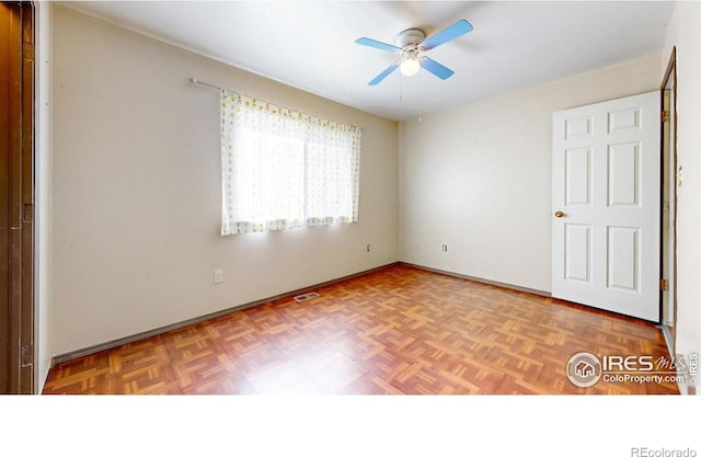 spare room with parquet floors and ceiling fan