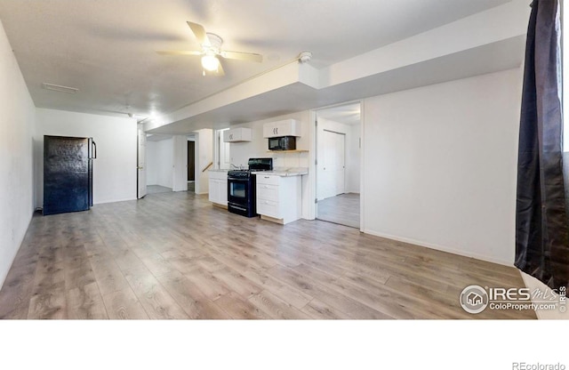 unfurnished living room featuring ceiling fan and light hardwood / wood-style flooring