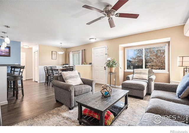 living room with wood-type flooring and ceiling fan