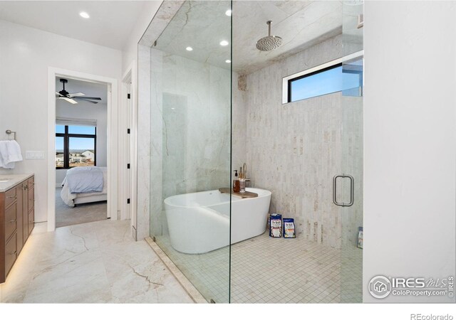 bathroom featuring ceiling fan, separate shower and tub, vanity, and a wealth of natural light