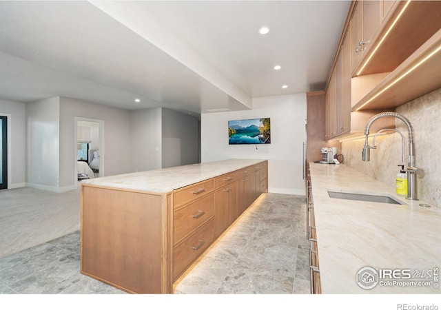 1722 Fire Glow Dr, Windsor, CO 80550 - kitchen with a sink, recessed lighting, light stone countertops, baseboards, and tasteful backsplash