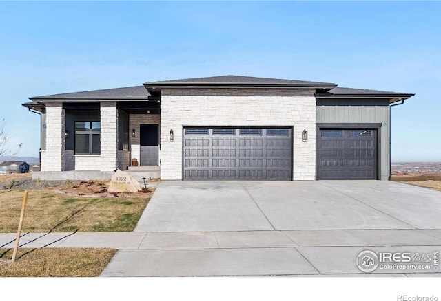 1722 Fire Glow Dr, Windsor, CO 80550 - prairie-style home featuring a garage, driveway, and stone siding