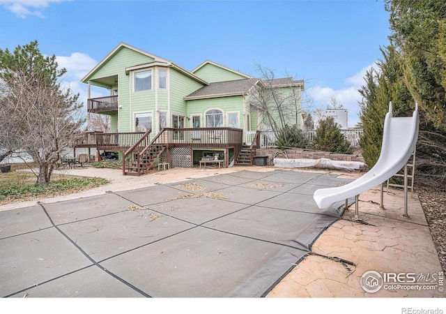 back of house with a deck and a patio