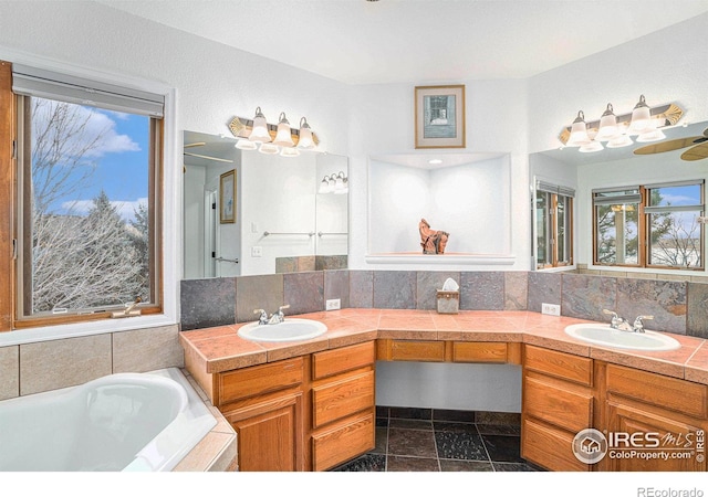 bathroom with a bathing tub, vanity, and backsplash