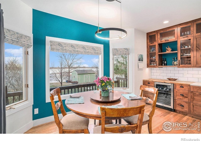 dining area featuring a wealth of natural light, light hardwood / wood-style floors, and wine cooler