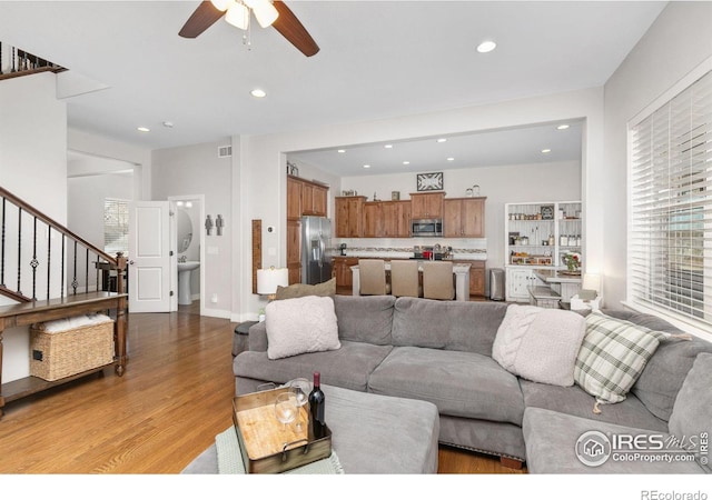 living room with ceiling fan and light hardwood / wood-style flooring