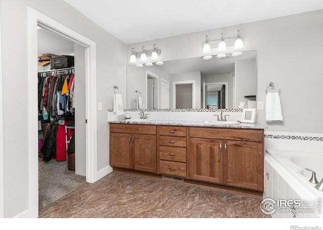 bathroom with vanity and tiled tub