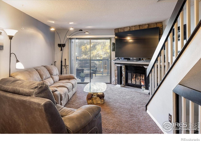 living room featuring carpet, a textured ceiling, and a stone fireplace