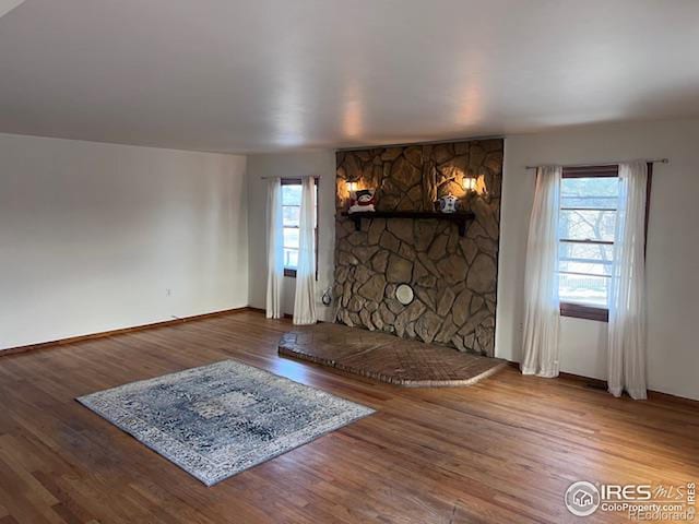 unfurnished living room featuring wood-type flooring and a wealth of natural light