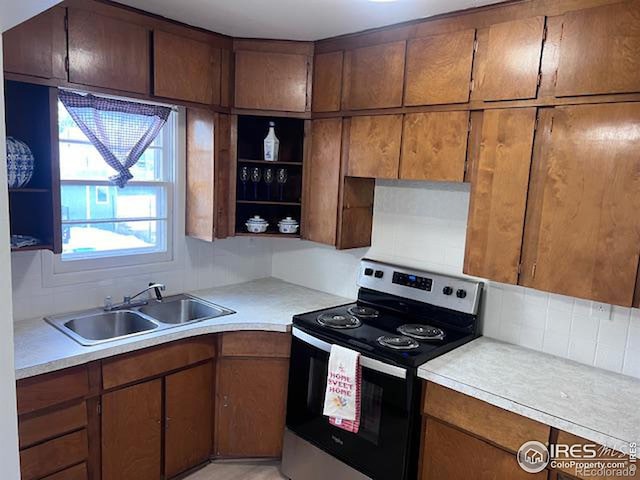 kitchen featuring backsplash, electric stove, and sink