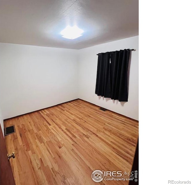 empty room with hardwood / wood-style floors