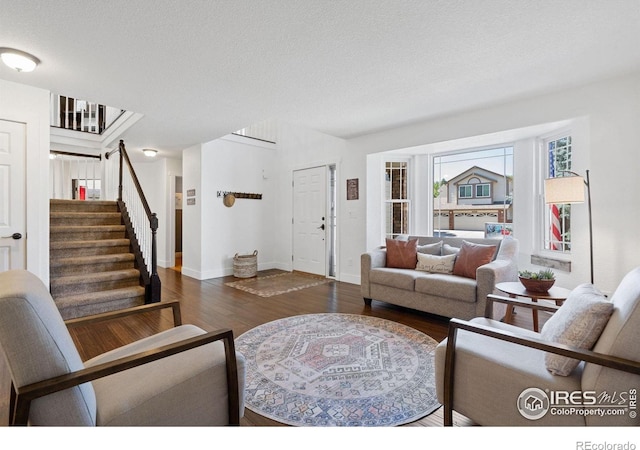 living room with dark wood-type flooring and a textured ceiling