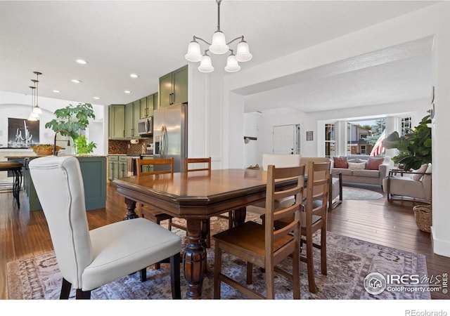 dining space featuring dark wood-type flooring and a notable chandelier