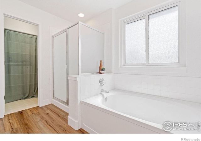 bathroom featuring wood-type flooring and independent shower and bath