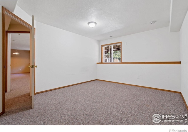 carpeted spare room featuring a textured ceiling