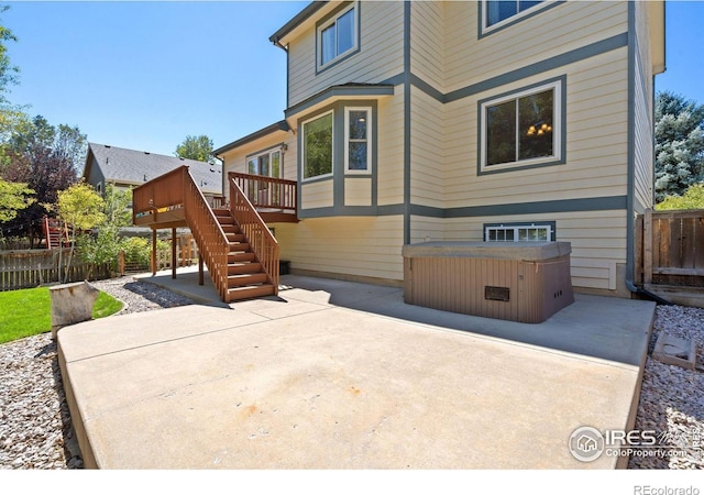 back of house featuring a patio, a hot tub, and a wooden deck