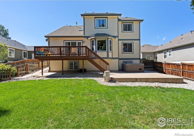 back of property featuring a deck, a patio area, and a lawn