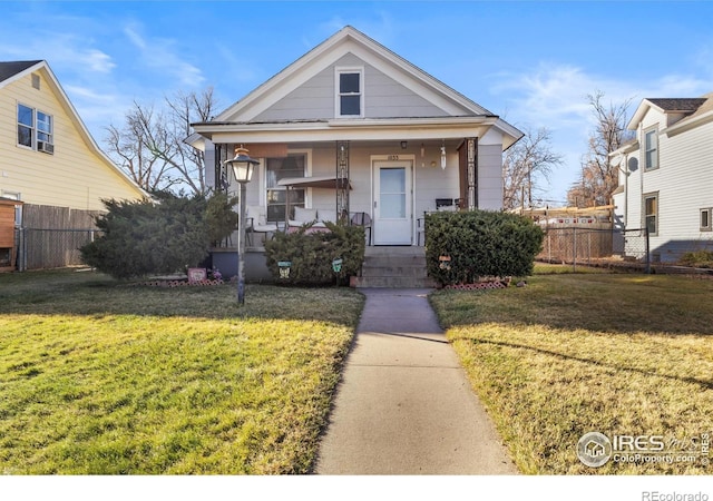 bungalow-style home with covered porch and a front yard