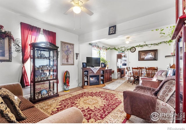 living room featuring ceiling fan and a fireplace