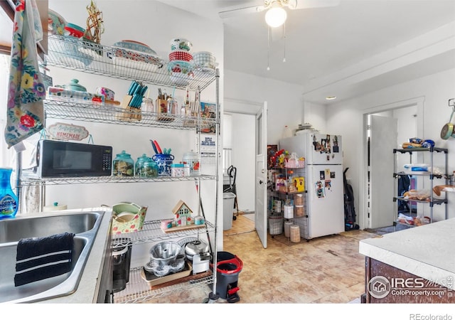 kitchen featuring ceiling fan, sink, and white refrigerator