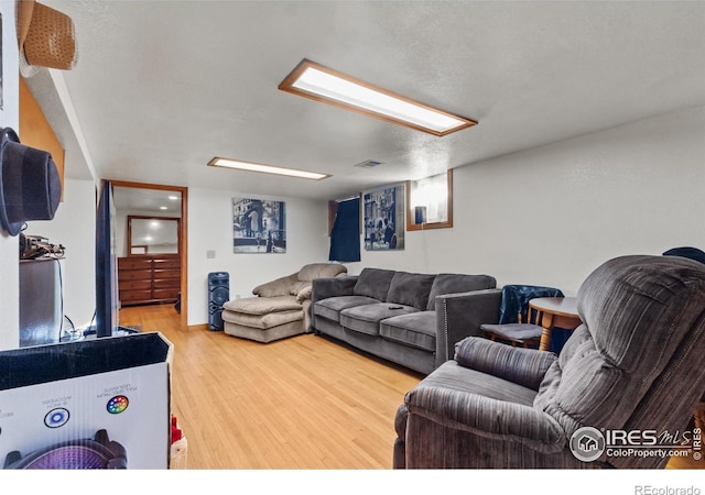 living room with wood-type flooring and a textured ceiling