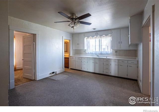 kitchen with backsplash, sink, ceiling fan, a textured ceiling, and white cabinetry