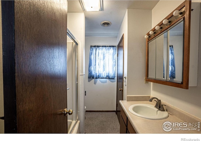 bathroom with vanity and bath / shower combo with glass door