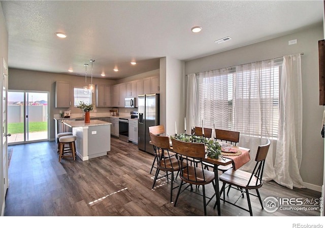 dining area with dark wood-type flooring and a textured ceiling