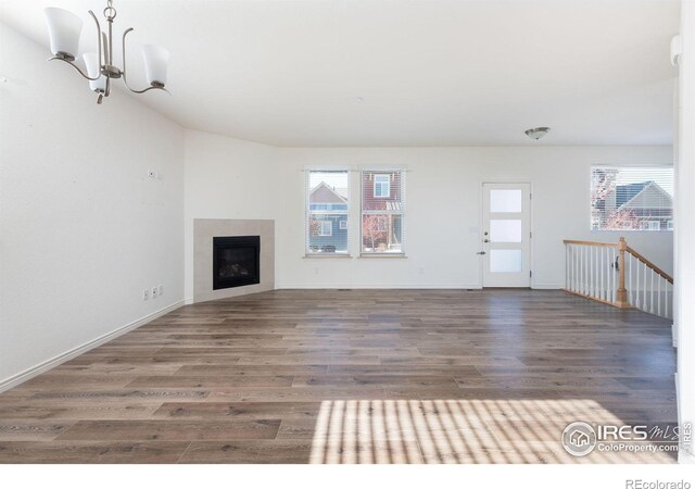 unfurnished living room with a chandelier and dark wood-type flooring