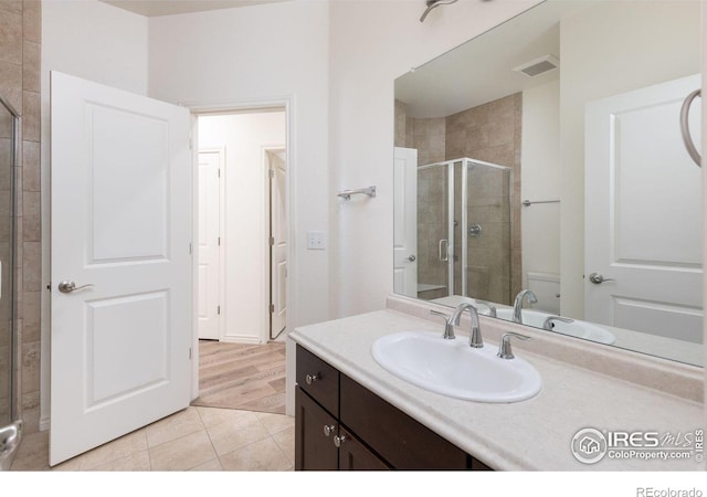 bathroom featuring hardwood / wood-style floors, vanity, and an enclosed shower