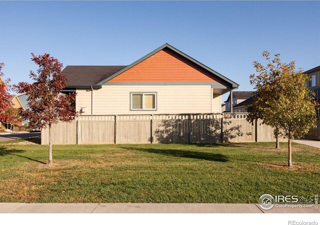 view of side of home with a yard