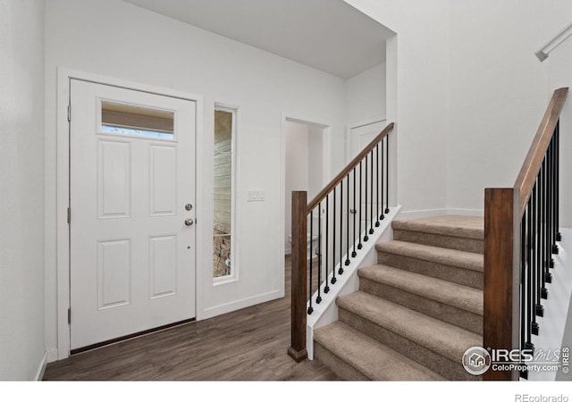 entryway with stairs, wood finished floors, and baseboards