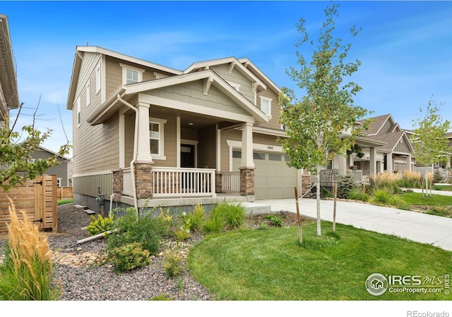 craftsman inspired home with a porch, concrete driveway, stone siding, and a garage