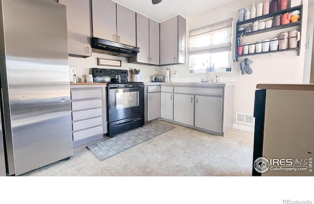 kitchen featuring black electric range, gray cabinets, stainless steel refrigerator, and sink