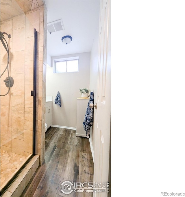 bathroom featuring hardwood / wood-style flooring and a shower with shower door