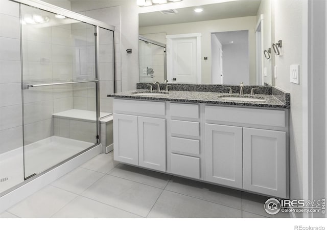 bathroom featuring tile patterned flooring, vanity, and an enclosed shower