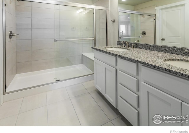 bathroom featuring tile patterned flooring, vanity, and an enclosed shower