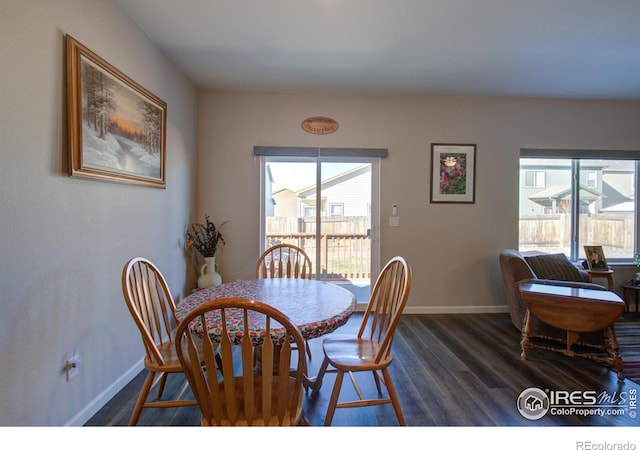 dining area with a wealth of natural light and dark hardwood / wood-style floors