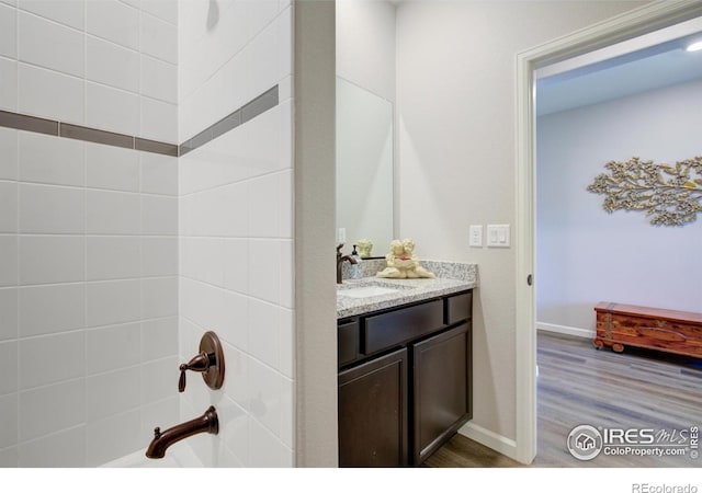 bathroom featuring vanity, hardwood / wood-style flooring, and tiled shower / bath