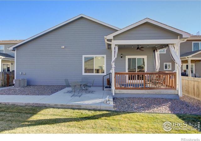 rear view of property featuring ceiling fan, a patio area, a yard, and central AC